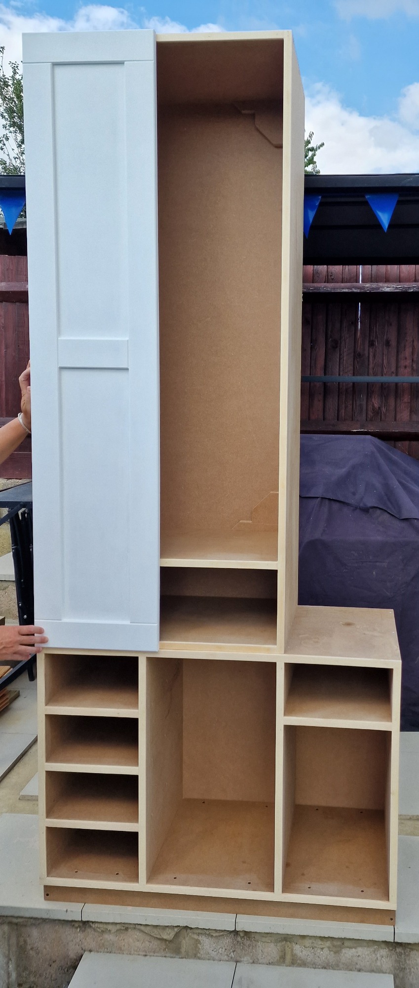 Tall, wooden storage unit with an open section and multiple compartments.