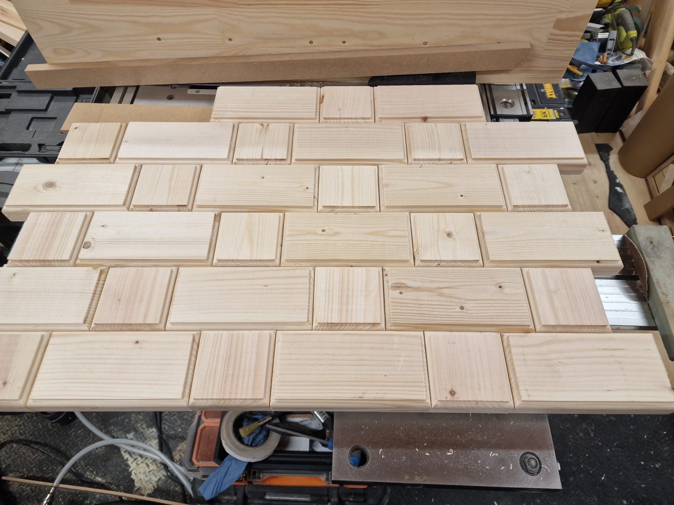 Various wooden planks arranged in a brick pattern on a work surface.