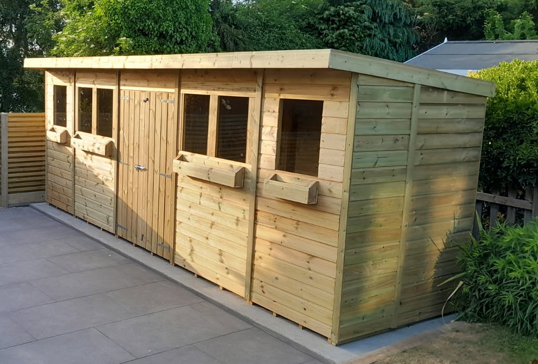 Wooden garden shed with multiple windows and a door, set on a patio.